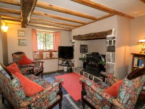 a living room with two couches and a fireplace at Bell Buoy Cottage in Bude