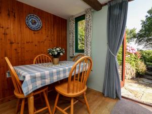 comedor con mesa, sillas y ventana en Bell Buoy Cottage, en Bude