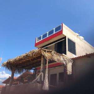 ein Gebäude mit einem Strohdach in der Unterkunft Pousada O Mineiro - frente a praia in Galinhos