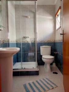 een badkamer met een douche, een toilet en een wastafel bij Casa da Sao in Nazaré