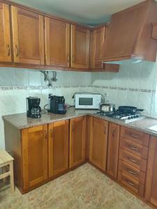 een keuken met houten kasten en een witte magnetron bij Casa da Sao in Nazaré +8 foto's