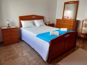 een slaapkamer met een bed met spiegel en een ladekast bij Casa da Sao in Nazaré