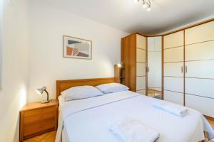 ein Schlafzimmer mit einem großen weißen Bett mit weißer Bettwäsche in der Unterkunft Apartment Seaside in Zaboric