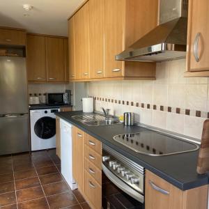 a kitchen with a sink and a stove at Apartamento Pirineos, Urb Las Margas Golf in Sabiñánigo