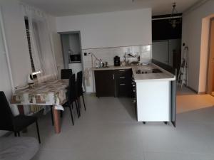 a kitchen and dining room with a table and chairs at Fenyő Windsurf vendégház in Révfülöp