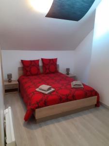 a bedroom with a red bed with red pillows at Maison au pays D' Aristide Bruand - Rose-Marie-Courtenay in Courtenay