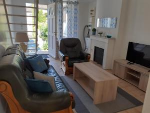 a living room with a couch and chairs and a tv at Maison au pays D' Aristide Bruand - Rose-Marie-Courtenay in Courtenay