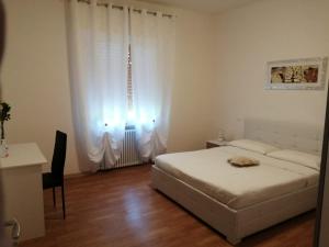 a bedroom with a bed and a desk and a window at Due Magnolie in Monzambano