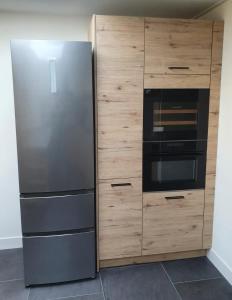 um frigorífico de aço inoxidável ao lado de um armário de madeira em Biedebure em Colijnsplaat