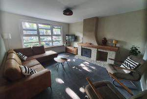 uma sala de estar com dois sofás e uma lareira em Biedebure em Colijnsplaat