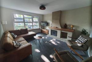 Una sala de estar con dos sofás y una chimenea. en Biedebure, en Colijnsplaat