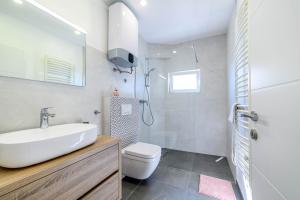 ein weißes Badezimmer mit Waschbecken und Toilette in der Unterkunft Apartment Seaside in Zaboric + 37 Fotos