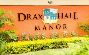 a sign for the drx hall manor at Ochi Rios ApartHotel by JHH in Ocho Rios