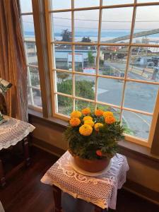 een vaas met bloemen op een tafel voor een raam bij Rodmay Hotel in Powell River