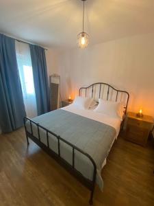 a bedroom with a large bed with blue curtains at Holiday Home - Boanerges Heritage in Blato na Cetini