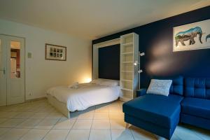 une chambre avec un lit et un canapé bleu dans l'établissement Le Bleu du Lac - 150m from the lake - terrace & parking in Sevrier, à Sévrier