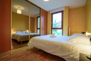 une chambre avec deux lits et un miroir dans l'établissement Le Bleu du Lac - 150m from the lake - terrace & parking in Sevrier, à Sévrier