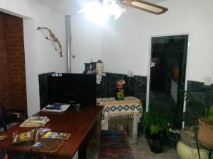 a living room with a desk and a tv at Hotel Foxes in Villa del Dique