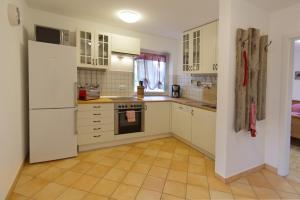 a kitchen with white cabinets and a white refrigerator at Ferienwohnung Arzgrube in Mittenwald