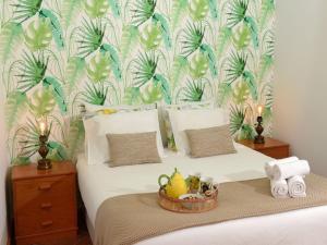 a bedroom with a bed with a tropical wallpaper at Flamingo Apartment in Furnas