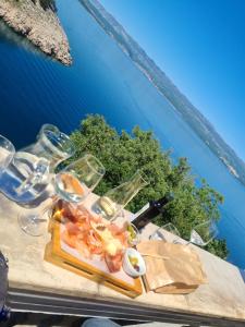 una mesa con un plato de comida y copas de vino en Villa Carpe Diem, en Vantačići