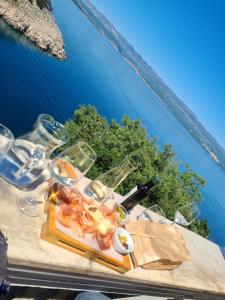 a table with a plate of food and wine glasses at Villa Carpe Diem in Vantačići