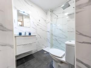 La salle de bains blanche est pourvue de toilettes et d'un lavabo. dans l'établissement Private Rooftop & Elegant studio - Center by REMS, à Malaga