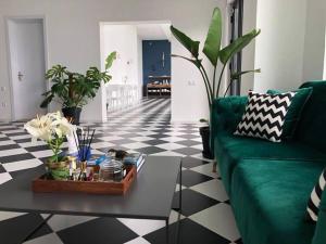 een woonkamer met een groene bank en een tafel bij Cabo Verde Boutique Hotel in Batoemi