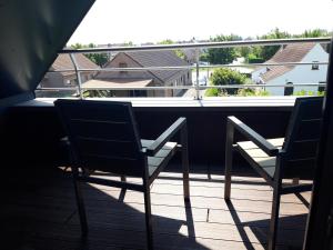 two chairs sitting on a balcony with a view at Duplex met zwembad Neoportus in Nieuwpoort