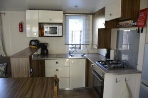 Η κουζίνα ή μικρή κουζίνα στο MOBILHOME 6/8 Personnes 3Ch LA RESERVE ****