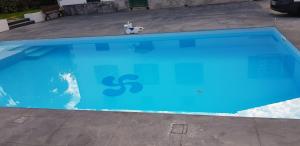 a teddy bear sitting next to a blue swimming pool at Chambre d'Hôtes Moulin Urketa in Ayherre