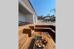 una terraza de madera con un bol de fruta. en Villa moderne avec Piscine - Porticcio, en Grosseto-Prugna