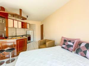 1 dormitorio pequeño con 1 cama y cocina en Estúdio bem localizado no Centro de Florianópolis N209 en Florianópolis