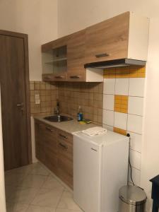 a kitchen with a white refrigerator and a sink at Krinides Suites in Nerotriviá +12 photos