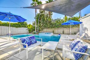 a swimming pool with chairs and umbrellas next to a pool at Riviera Palm Springs Permit# 2044 in Palm Springs