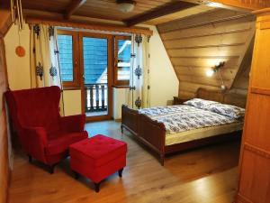 ein Schlafzimmer mit einem Bett und einem roten Stuhl in der Unterkunft Willa pod Limbami in Zakopane