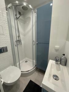 uma casa de banho com um chuveiro, um WC e um lavatório. em Chill Apartament Gdynia em Gdynia