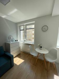 uma sala de estar com uma mesa e cadeiras e uma janela em Chill Apartament Gdynia em Gdynia