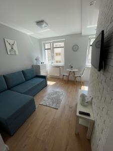 uma sala de estar com um sofá azul e uma mesa em Chill Apartament Gdynia em Gdynia