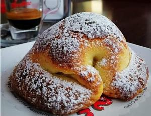 two donuts covered in powdered sugar sitting on a plate at New Casa bluchic in Isola delle Femmine +35 photos