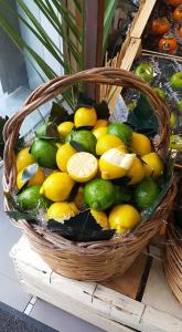 a basket filled with lemons and limes on a table at New Casa bluchic in Isola delle Femmine