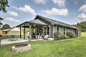a small house with a patio and a fire pit at Mountain Home Cottage with Deck on White River! in Gassville