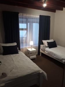 Un dormitorio con dos camas y una ventana. en The Lofts (Mossel Bay), en Mossel Bay