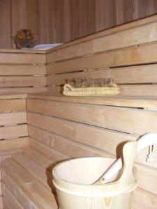 a bathroom with a wooden wall with a white tub at Camping Village Yolki Palki in Bognanco