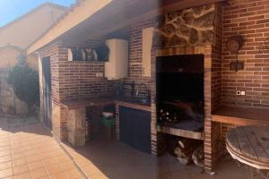 una cocina al aire libre con una pared de ladrillo y un horno en Chalet Boccherini, en Arenas de San Pedro