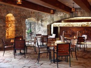 a restaurant with wooden tables and chairs and a stone wall at Hotel Racquet Cuernavaca in Cuernavaca