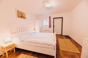 a bedroom with a white bed and a wooden floor at Chalupa Šakvice l Jižní Morava l Pálava in Šakvice