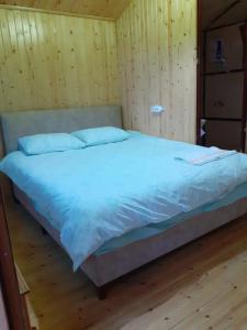 a large bed in a room with wooden walls at BEYCIK PANORAMA CAMPING in Kemer