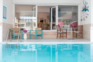 Beldibi的住宿－Olya Boutique Hotel，房屋旁的游泳池配有桌椅