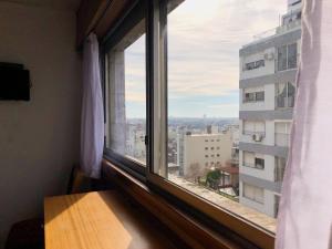 een raam met uitzicht op de stad bij Hotel Continental in Montevideo